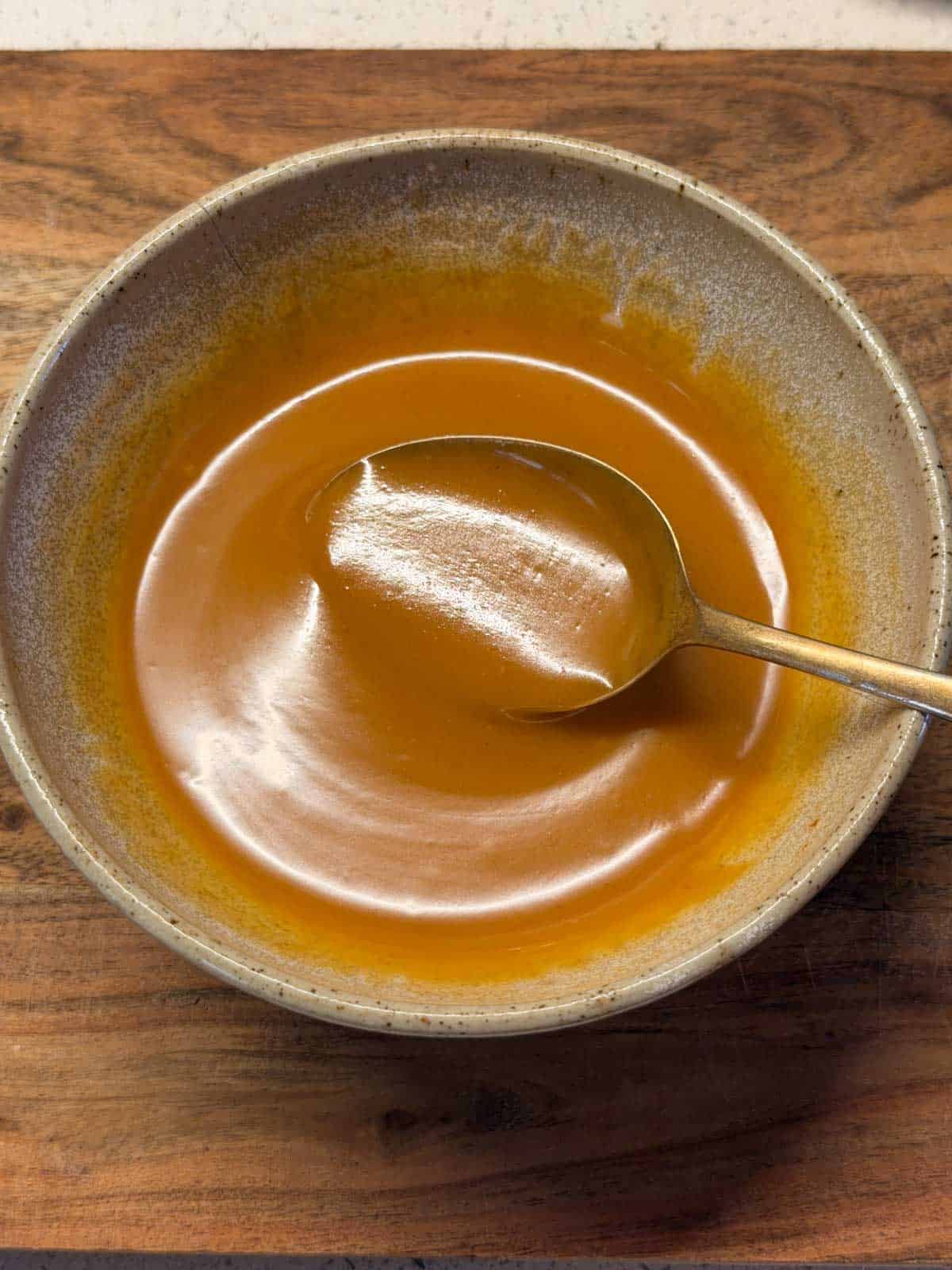 an image of peanut butter salad dressing in a bowl with spoon 
