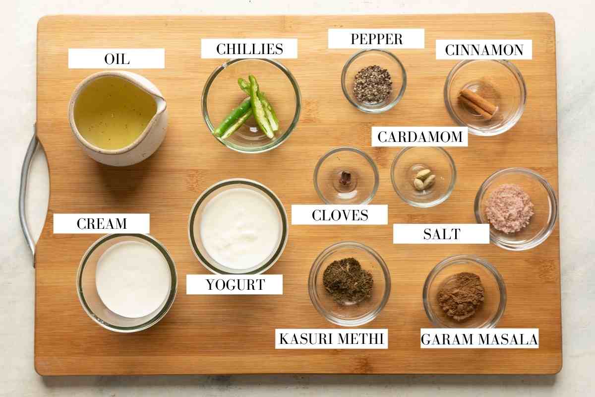 Ingredients for making the gravy for chicken kali mirch on a brown board with text to identify them