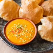 picture of aam ras on a plate with many puris