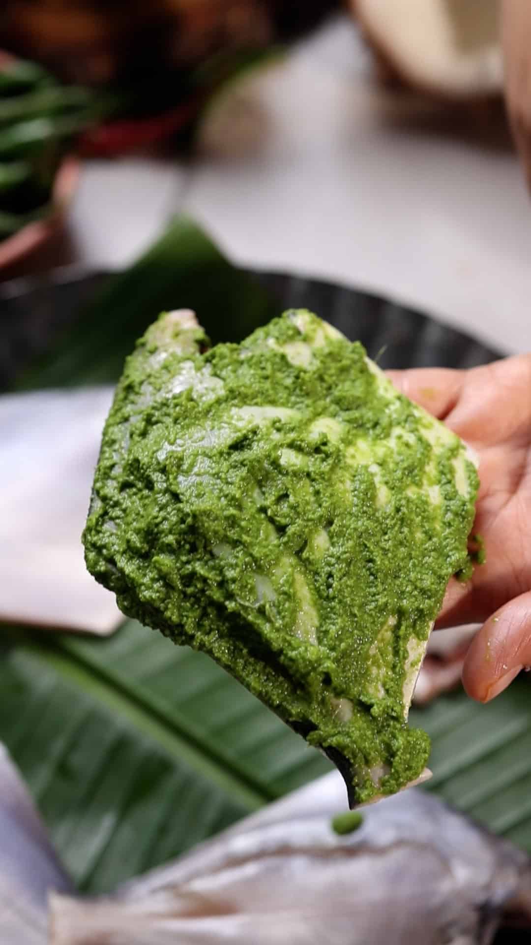a close up of pomfret fish marinated in the green masala to showcase it's texture and color