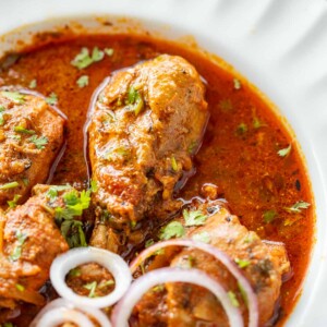 pressure cooker chicken curry served with sliced onion rings