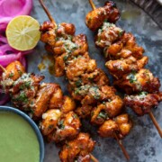 an image of achari chicken tikkas served in a plate with accompaniments