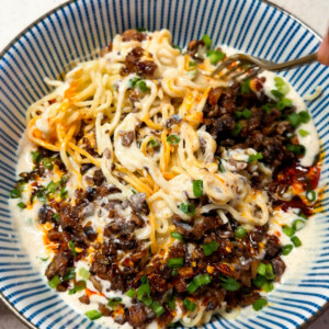 freshly made creamy chilli noodles in a bowl along with a fork