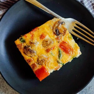 A slice of baked denver omelet breakfast casserole on a plate.