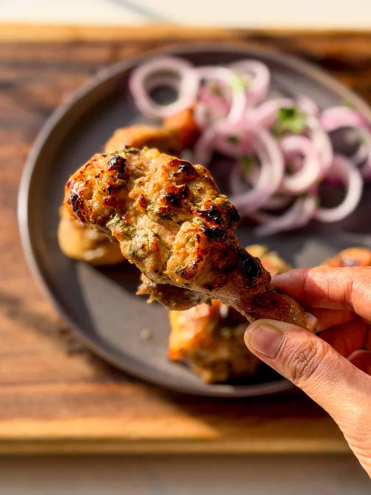 a close up image of air fryer malai chicken tikka to showcase it's color and texture