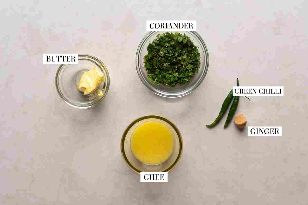Ingredients for the tempering or tadka laid out on a marble with text to identify them